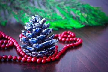 New Year's colorful cones and branches of a green Christmas tree with decor in the form of red beads