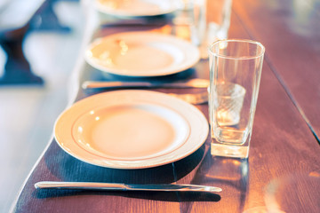 served table with empty plates, glass goblets and, forks, knives. cutlery in the restaurant