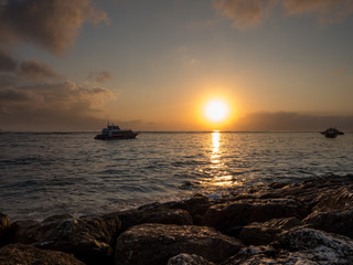 Ancient traditional fishing boat on seashore at colorful sunrise. Sanur beach, Bali, Indonesia. October, 2018