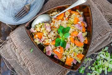 Pearl barley and bacon cassarole with carrots, leek and savoy cabbage - top view