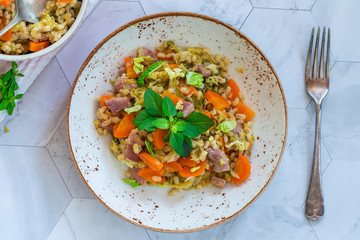 Pearl barley and bacon cassarole with carrots, leek and savoy cabbage - top view