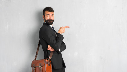Businessman with beard pointing finger to the side in lateral position
