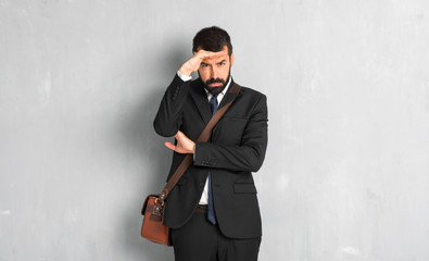 Businessman with beard looking far away with hand to look something
