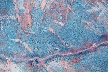 Limestone artistic uneven fractured with long crack texture background in blue, pink and orange...