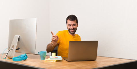 Man working with laptot in a office enjoy dancing while listening to music at a party