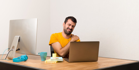Man working with laptot in a office suffering from pain in shoulder for having made an effort