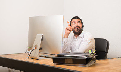 Telemarketer man in a office pointing a great idea and looking up