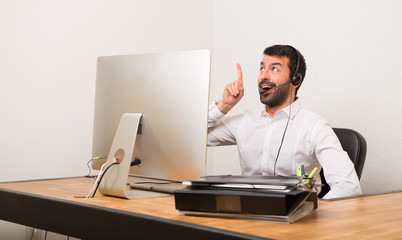 Telemarketer man in a office intending to realizes the solution while lifting a finger up