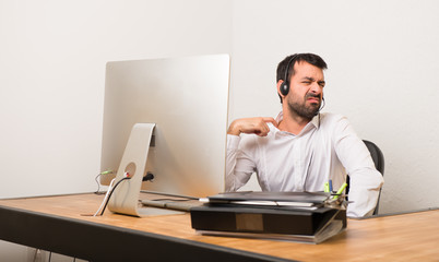 Telemarketer man in a office with tired and sick expression