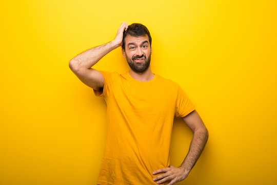 Man on isolated vibrant yellow color with an expression of frustration and not understanding