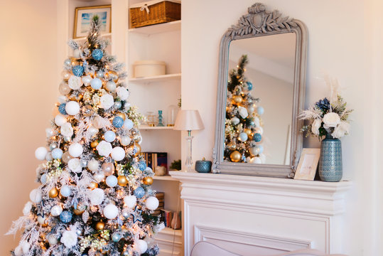 Interior Of Cozy Room Decorated In Christmas Happy New Year Style. No People. An Empty Sofa, Christmas Tree With Presents Under It. Selective Focus. Happy NY Mood