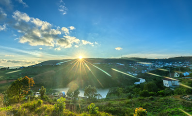 Dawn on plateau in morning with colorful sky, while sun rising from horizon shines down to small village landscape so beautiful idyllic countryside Dalat plateau, Vietnam