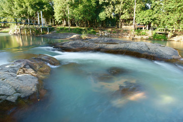 blue stream or rapids river with tree and rock or stone and cottage with bridge in green jungle or forest on warm sunlight for summer or winter holiday relax and vacation travel trip at National Park