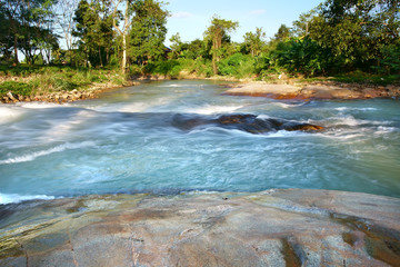blue stream or rapids river with tree and rock or stone and cottage in green jungle or forest on clear sky and sunlight for summer or winter holiday relax and vacation travel trip at National Park