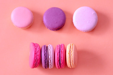 Colorful macaroons are on the pink background,