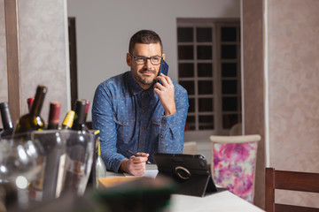 Hombre joven hablando por teléfono en bar de copas