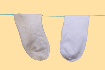 clean new white sock and next to the dirty old sock weighs