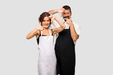 Couple of cooks focusing face. Framing symbol on grey background