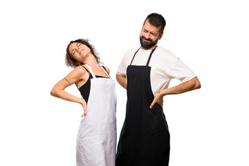 Couple of cooks suffering from backache for having made an effor on isolated white background