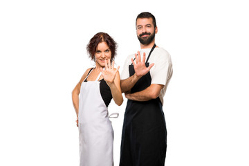 Couple of cooks counting five with fingers on isolated white background