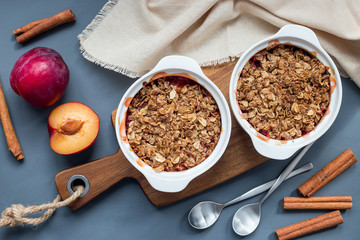 Plum crumble pie or plum crisp with oats and spices, in baking dish, top view, horizontal