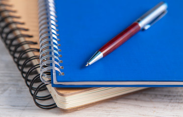 notebook and pen in wooden background
