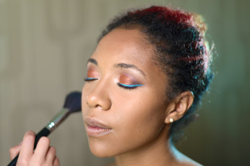 portrait of pretty girl with beautiful makeup. the master makes visage with brush