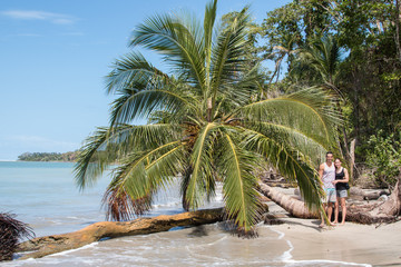 Junges Paar steht an einer einsamen Palme im Karibischen Meer in Costa Rica