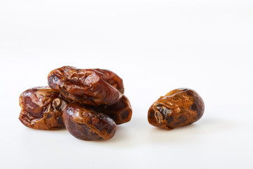 Dried halawi dates on a white