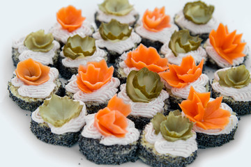 Close up of small canapes arranged on a plate over light background - selective focus