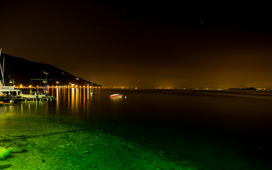 Fototapeta na wymiar Night view of Lake Garda and the illuminated villages on the west coast.