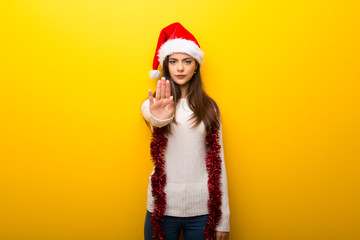 Teenager girl celebrating christmas holidays making stop gesture with her hand