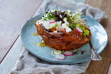 Sweet potato with mashed avocado, yogurt and sprouts