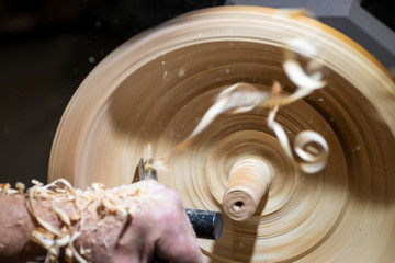 wood shavings in motion while turnery of a wooden bowl with chisel