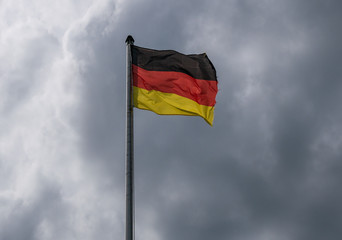 Flag of Germany against the cloudy sky