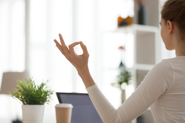Close up of focused woman meditating at home, hands in mudra position, concentrated girl practice...