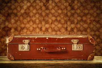 Retro old suitcase and dark wall background 