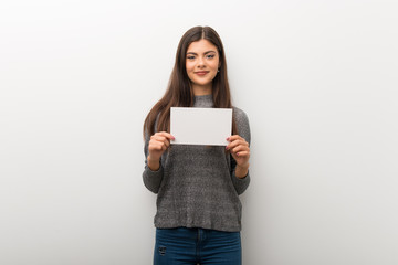 Teenager girl on isolated white backgorund holding a placard for insert a concept