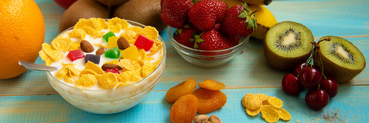Tasty cornflakes with milk and fruits  in glass bowl 