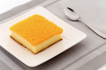 Golden egg strips topping on butter cake or Foi Thong cake on plate with spoon