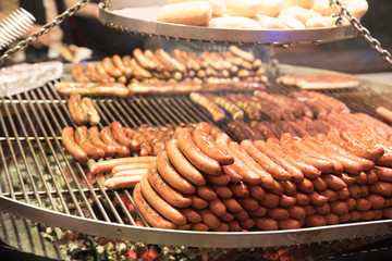 Grilling sausages on barbecue grill at a food stall of Christmas market winter wonderland in London