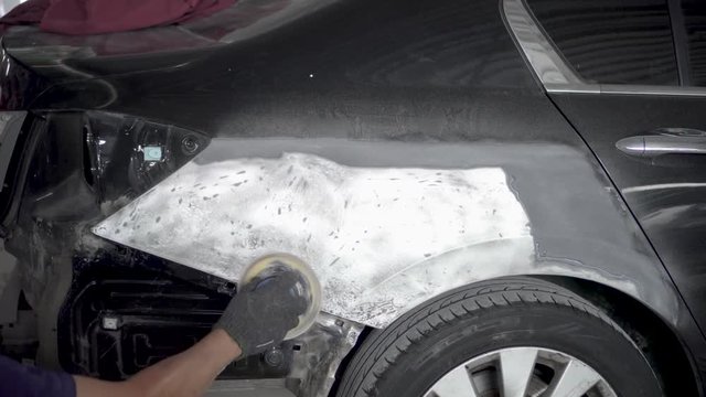 Car body work after the accident by preparing automobile for painting during repair