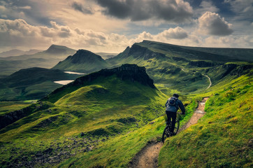 Mountain biker riding through rough mountain landscape of Quiraing, Scotland - obrazy, fototapety, plakaty