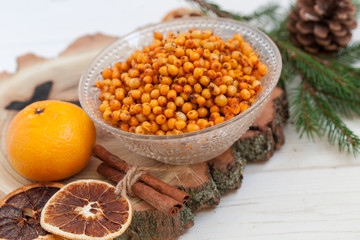 Orange and sea buckthorn on a white wooden background, christmas food,  concept of seasonal vitamins and healthy eating. Copy space