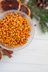 Orange and sea buckthorn on a white wooden background, christmas food,  concept of seasonal vitamins and healthy eating. Copy space