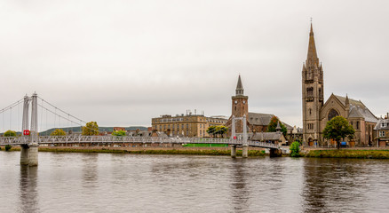Fototapeta na wymiar Bridge over river Ness and two churches on an opposite bank, Inverness, Scotland