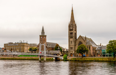 Fototapeta premium Bridge over river Ness leading to the famous tall gothic style Free Church of Scotland, Inverness