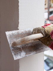 Worker is applying plaster on exteror column