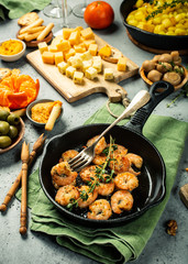 Prawns Shrimps roasted on frying cast iron pan with thyme and garlic. Party food background.