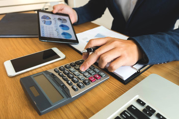 Businessmen calculate the income from the export business on the wood table.Business concept.